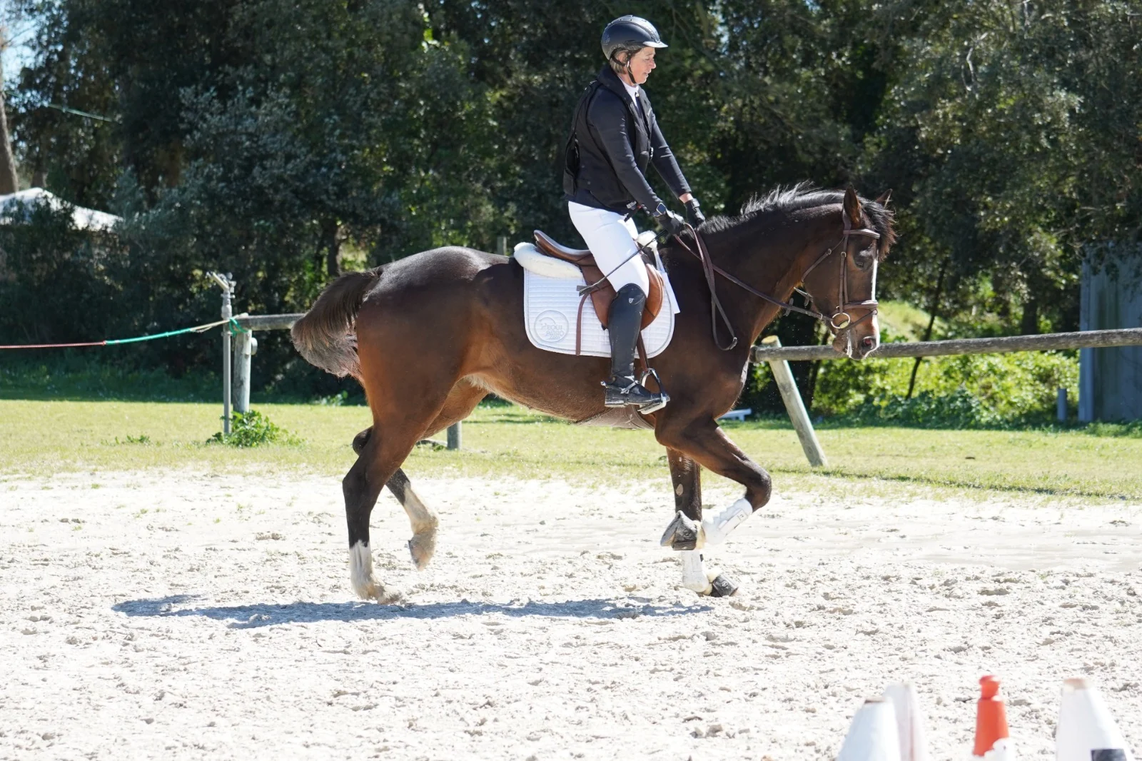 Claire van Gelder montando en una pista de arena con chaqueta de concurso