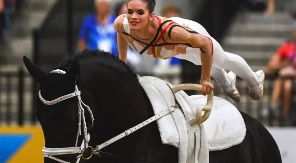 Volteadora ejecutando una figura sobre un caballo al galope
